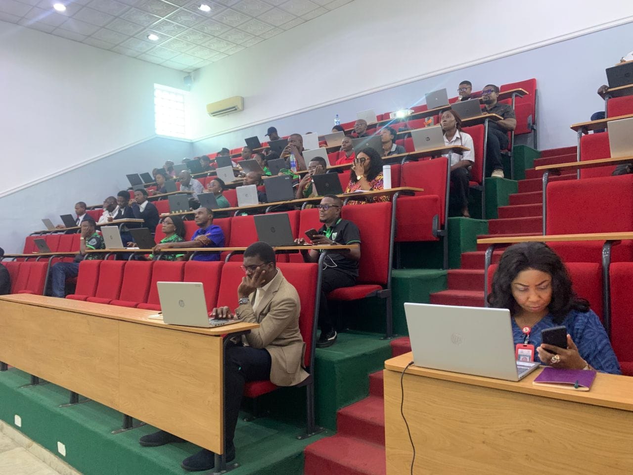 Participants working on laptops during a WalkTalk training session in a lecture hall