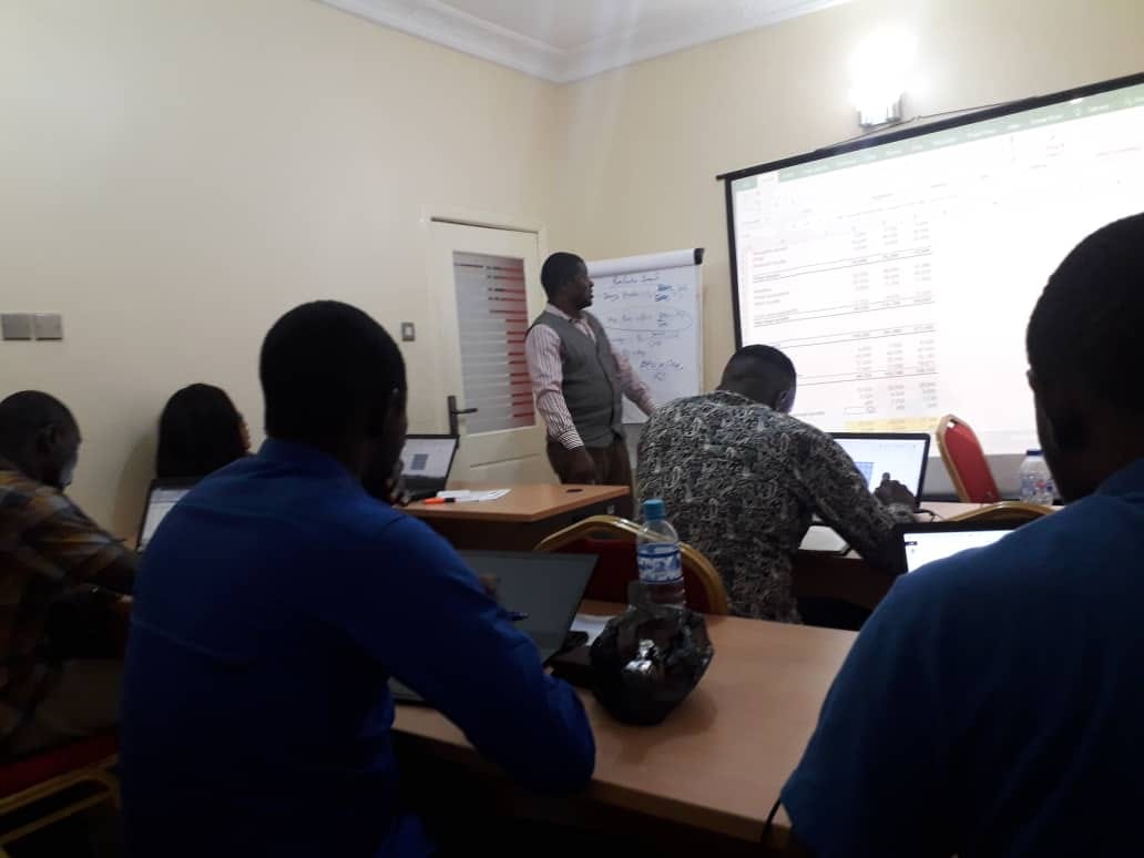 Facilitator reviewing a financial statement model projected on screen