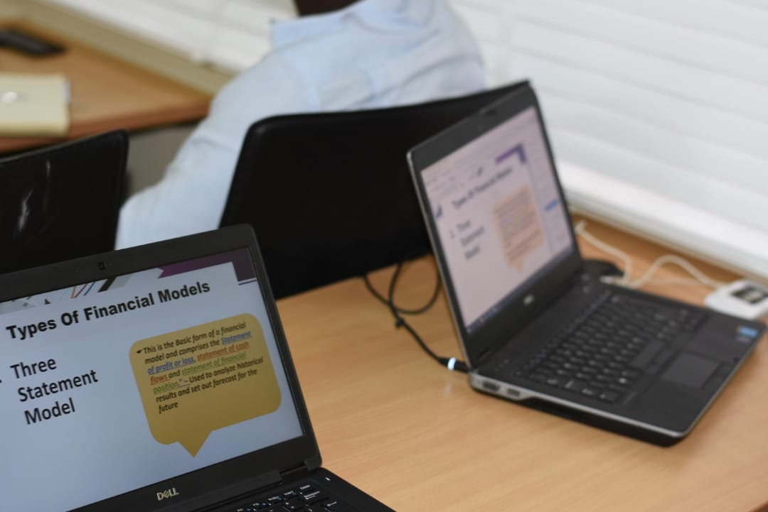 Close-up of laptops showing a slide on the types of financial models
