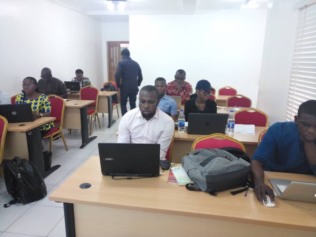 Delegates working through exercises on laptops in a bright training room