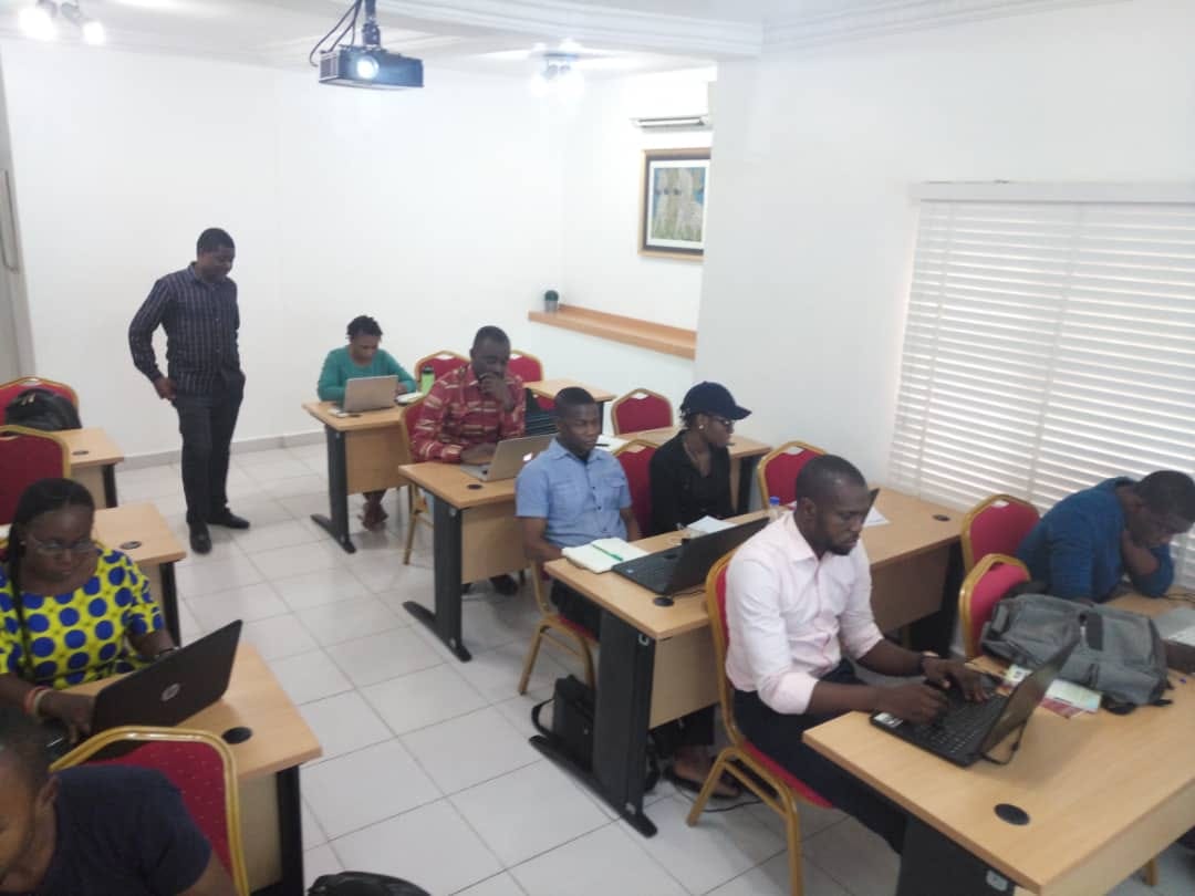 Facilitator walking the room while delegates practise on their laptops