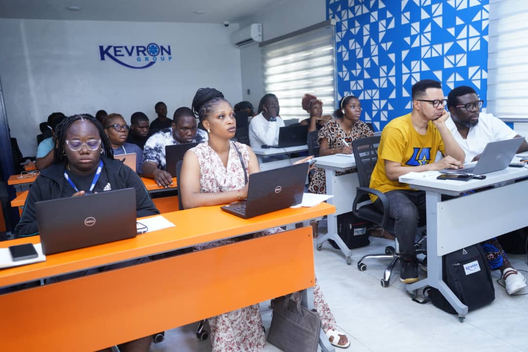Delegates following along on laptops in a corporate training room